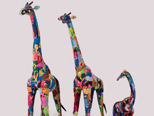 Three giraffe sculptures in many bright colors