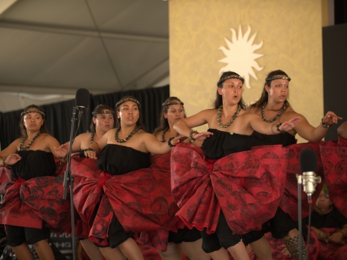 Women dance in red skirts and black tops.
